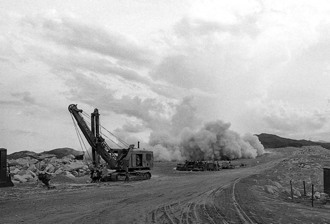 An explosion loosens another pile of granite from the quarry wall.